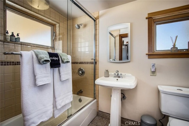 7716 Sunset Rd, Joshua Tree, CA 92252 - bathroom featuring shower / bath combination with glass door, a sink, tile patterned floors, and toilet