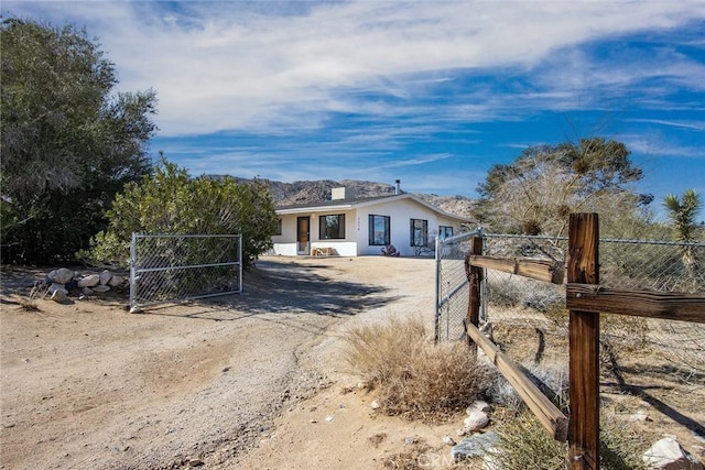 7716 Sunset Rd, Joshua Tree, CA 92252 - view of front of property with fence, a gate, and stucco siding