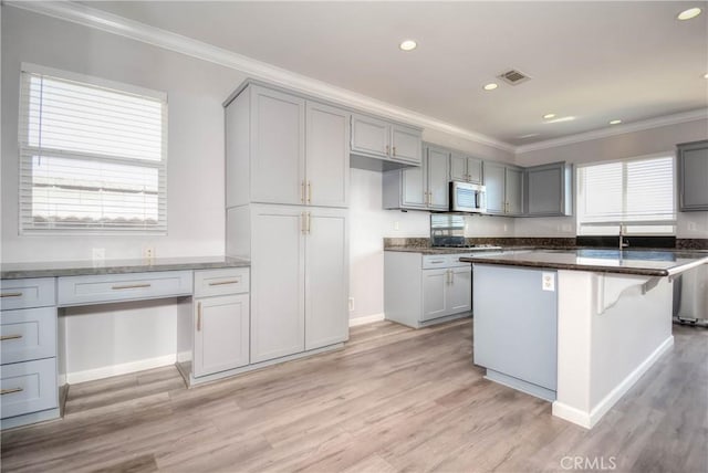 kitchen featuring ornamental molding, gray cabinets, visible vents, and light wood-style flooring