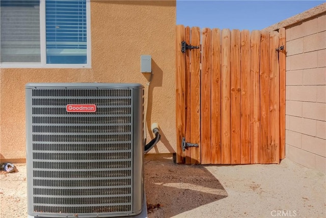 exterior details featuring central AC unit, a gate, and stucco siding