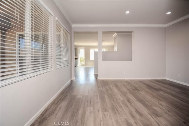 interior space featuring ornamental molding, recessed lighting, baseboards, and wood finished floors