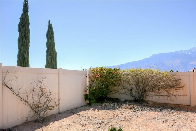 view of yard featuring a fenced backyard and a mountain view