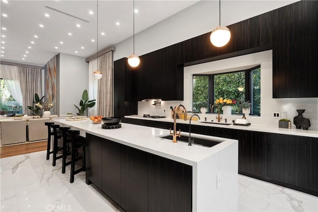 kitchen with marble finish floor, modern cabinets, a sink, and light countertops