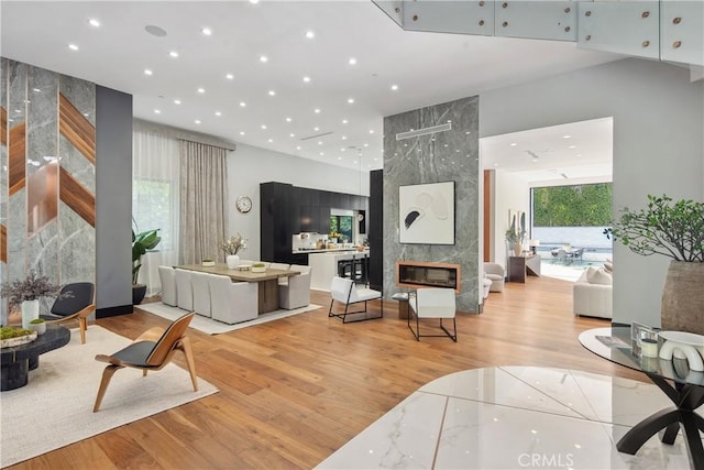 living area with a premium fireplace, wood finished floors, and recessed lighting