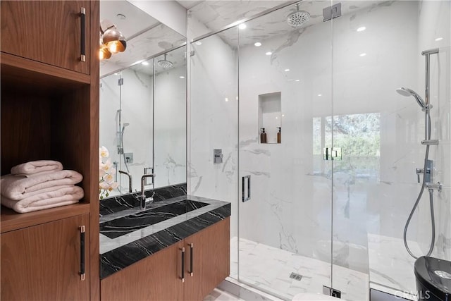 full bath with a marble finish shower and vanity