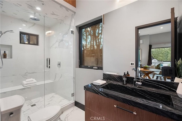 full bath featuring toilet, marble finish floor, a marble finish shower, and vanity