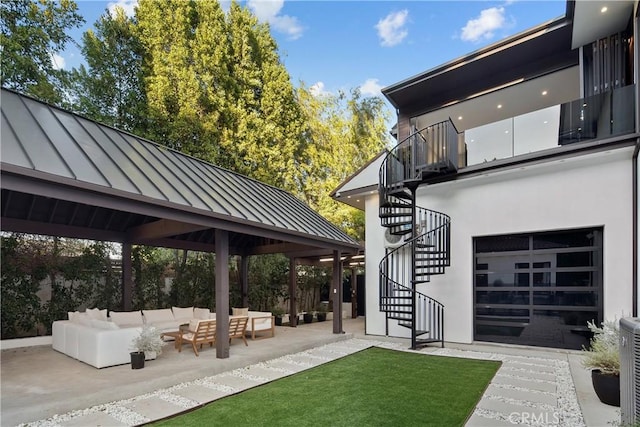 exterior space with a patio, stairway, an attached garage, and an outdoor hangout area