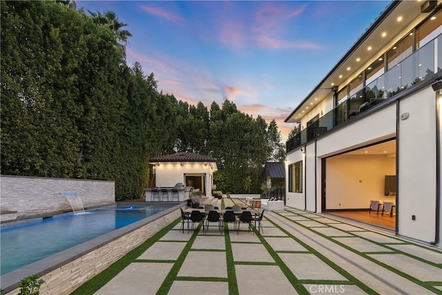 outdoor pool featuring a patio area, outdoor dining area, and area for grilling