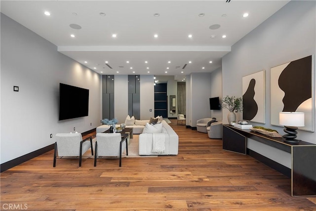 living room featuring recessed lighting, baseboards, and light wood finished floors