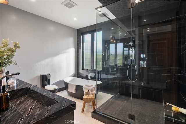 bathroom featuring a sink, a shower stall, visible vents, and a freestanding bath