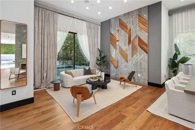 living area with recessed lighting, a fireplace, and wood finished floors