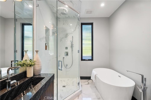 full bathroom with marble finish floor, a marble finish shower, a freestanding bath, and recessed lighting