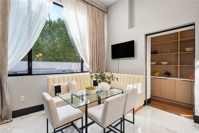 dining area featuring marble finish floor and baseboards