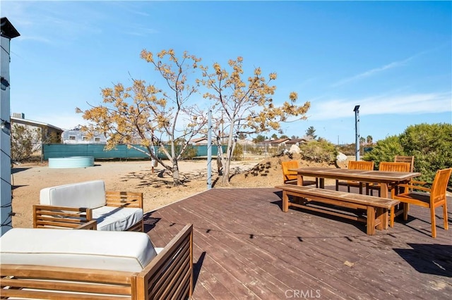 view of patio with outdoor dining space, fence, outdoor lounge area, and a wooden deck