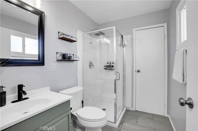 bathroom with a stall shower, vanity, and toilet