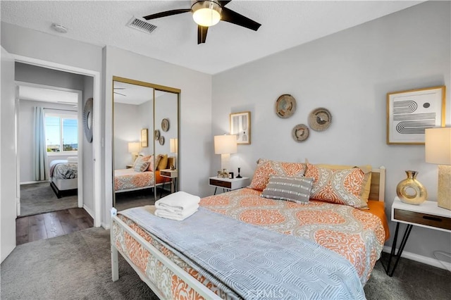 bedroom featuring carpet floors, visible vents, baseboards, a ceiling fan, and a closet