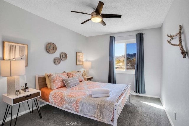 bedroom with carpet, ceiling fan, a textured ceiling, and baseboards