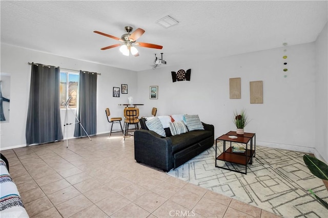 tiled living area featuring ceiling fan and baseboards