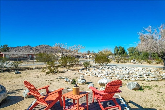 view of yard featuring fence and a mountain view