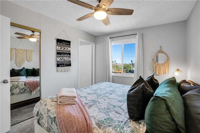 bedroom featuring carpet floors, ceiling fan, a textured ceiling, and a closet