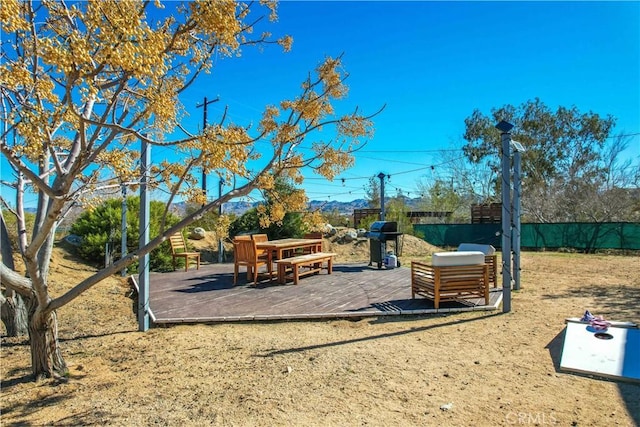 view of playground featuring fence and a wooden deck