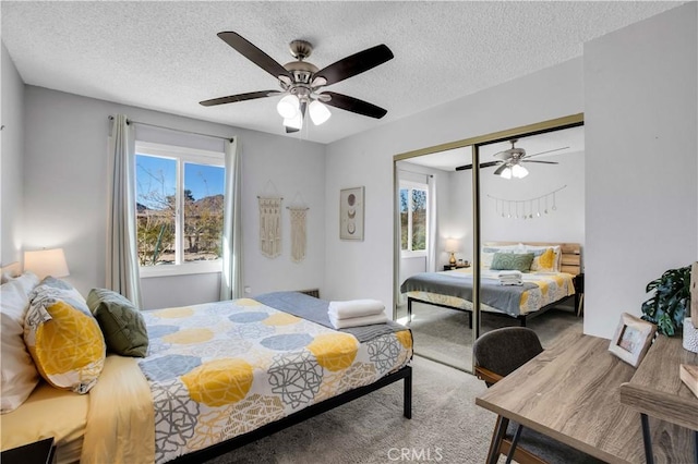 bedroom featuring carpet, a closet, a textured ceiling, and a ceiling fan