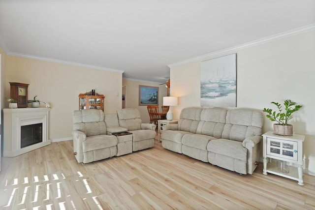 living area with ornamental molding, a glass covered fireplace, and wood finished floors