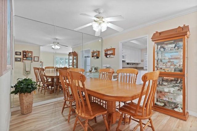 dining area with light wood-style floors, ceiling fan, and ornamental molding