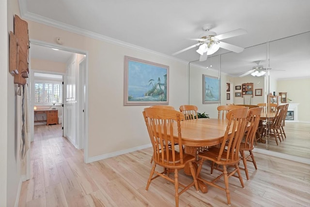 dining space with baseboards, light wood-type flooring, a ceiling fan, and crown molding