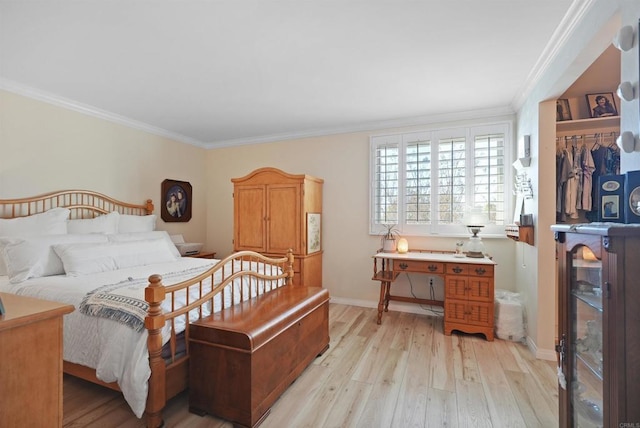 bedroom with ornamental molding, light wood finished floors, and baseboards