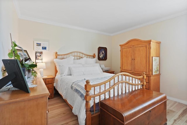 bedroom featuring baseboards, light wood finished floors, and crown molding