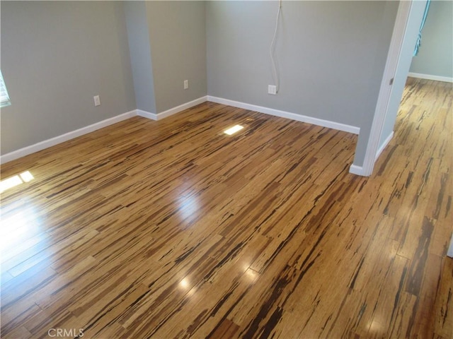 spare room featuring wood finished floors and baseboards