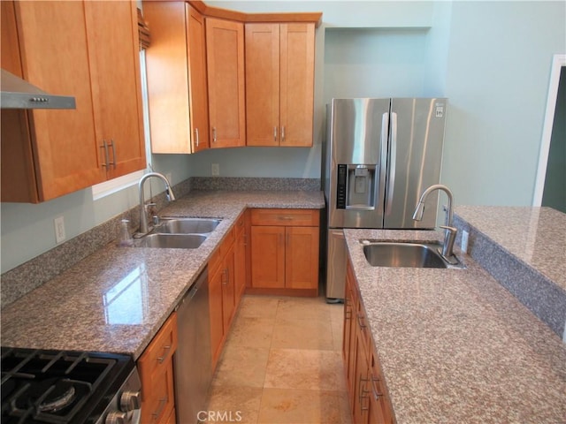 kitchen featuring brown cabinetry, stainless steel appliances, and a sink