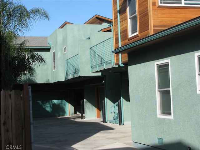 view of side of property featuring crawl space, a shingled roof, and stucco siding