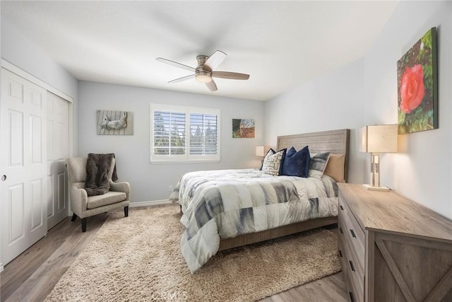 bedroom featuring light wood finished floors, a closet, a ceiling fan, and baseboards