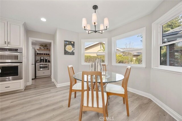 dining space featuring baseboards, recessed lighting, a chandelier, and light wood-style floors