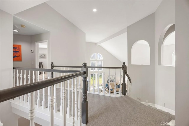 hall with vaulted ceiling with beams, carpet flooring, and baseboards