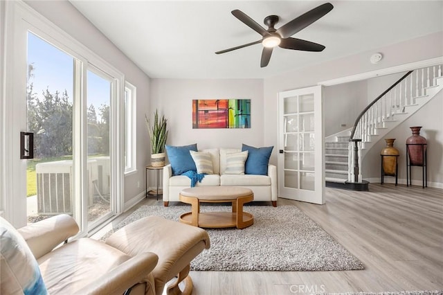 sitting room with stairs, french doors, wood finished floors, and baseboards