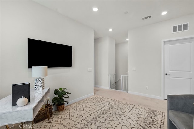 carpeted living area featuring recessed lighting, visible vents, and baseboards