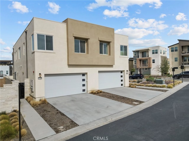 view of front of property with a garage, central air condition unit, driveway, and stucco siding