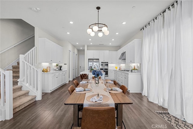 dining space featuring recessed lighting, dark wood-style flooring, an inviting chandelier, and stairs