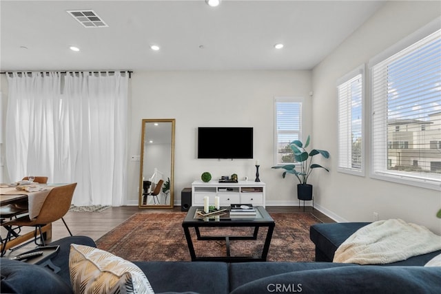 living room with baseboards, visible vents, wood finished floors, and recessed lighting