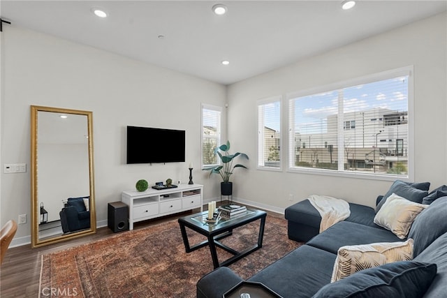 living area with baseboards, dark wood-type flooring, and recessed lighting