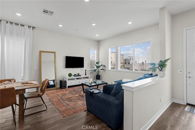 living room with baseboards, dark wood-style flooring, visible vents, and recessed lighting