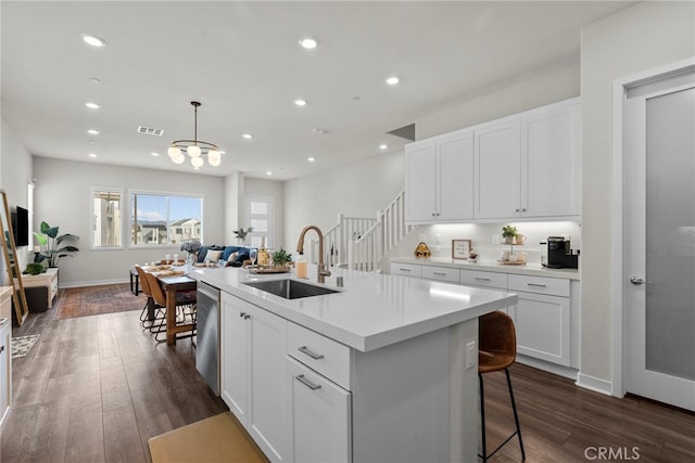 kitchen featuring dark wood-type flooring, visible vents, a sink, and dishwasher