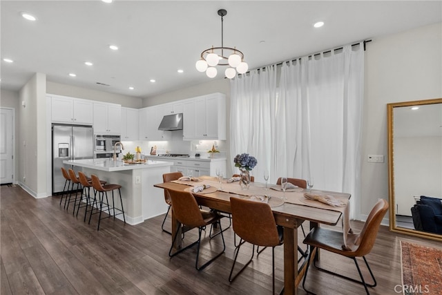 dining area featuring baseboards, dark wood finished floors, and recessed lighting