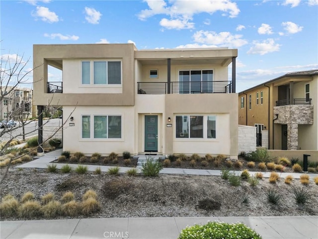 view of front of house with a balcony and stucco siding