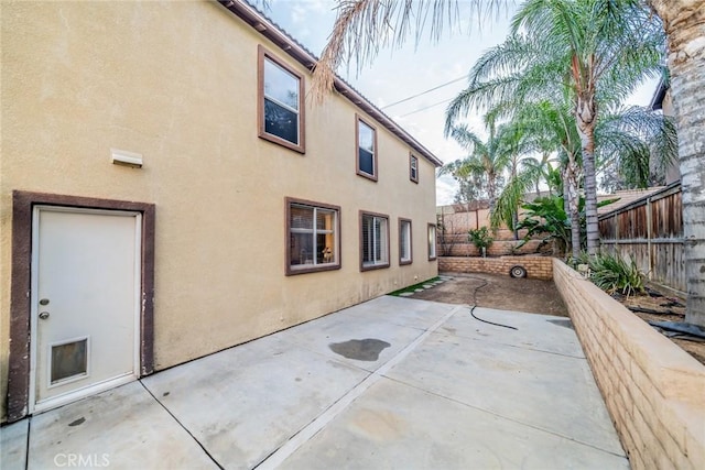 rear view of property with a patio area, a fenced backyard, and stucco siding