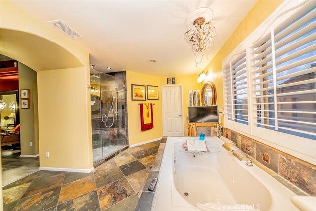 bathroom featuring a stall shower, baseboards, visible vents, and stone tile floors