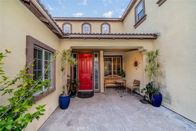 doorway to property featuring a patio area and stucco siding